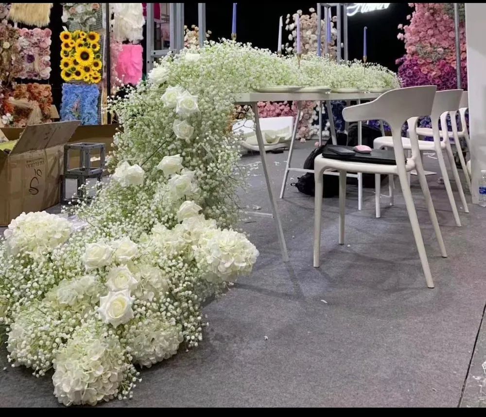White flowers cascade from a display table down to the floor.